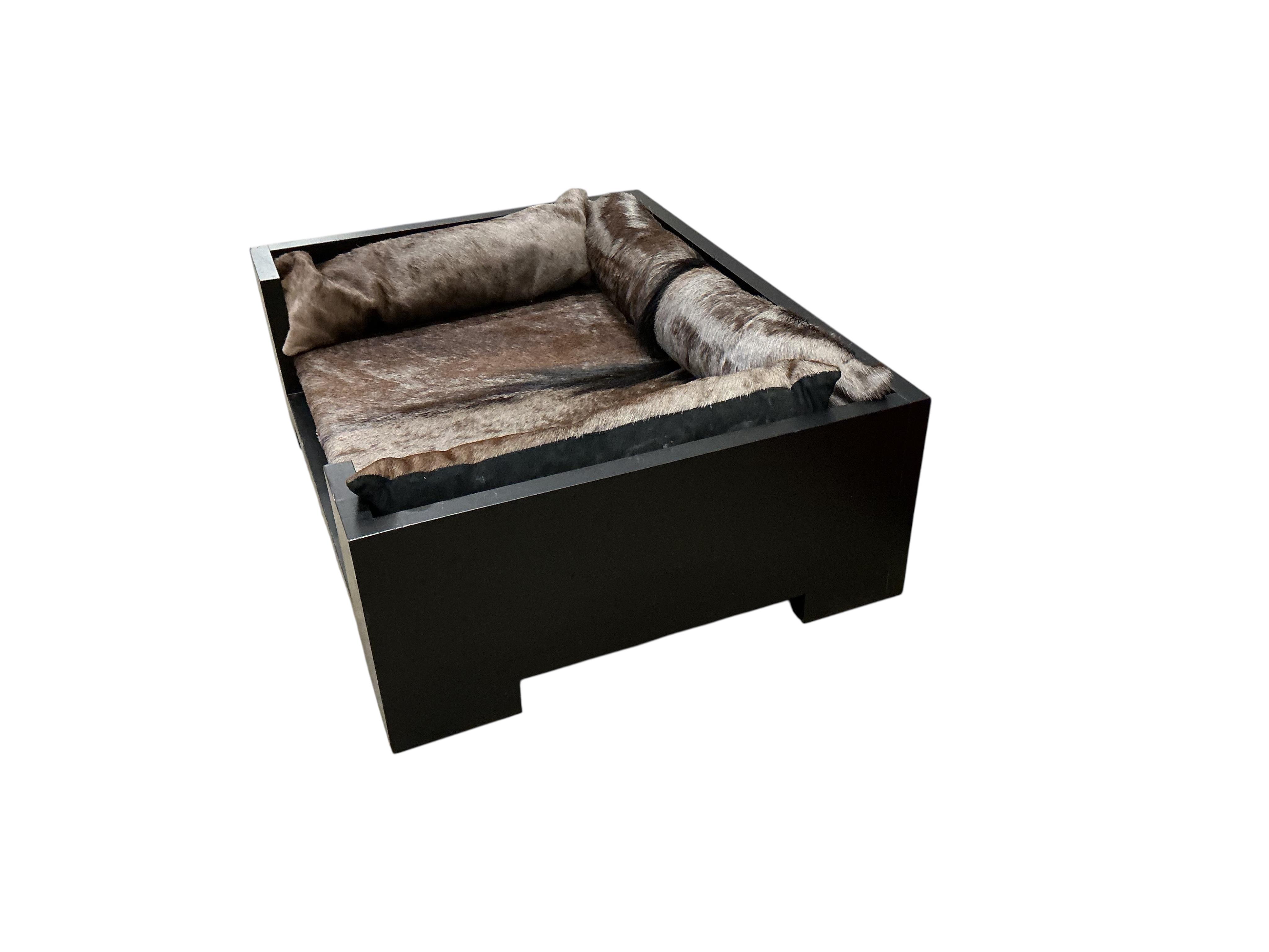 A contemporary ebonised dog bed with faux fur cushions, width 87cm, depth 67cm, height 29cm
